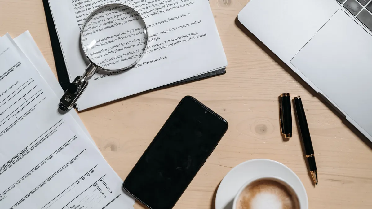 Bulk AI Content Quality Control — The Complete Guide desk covered with documents and a magnifying glass