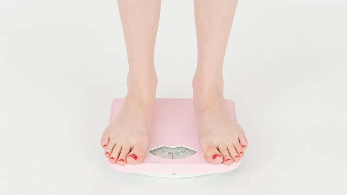 Fact-checking at scale: practical processes and tools to verify AI-written content — Woman checking weight on scales in 