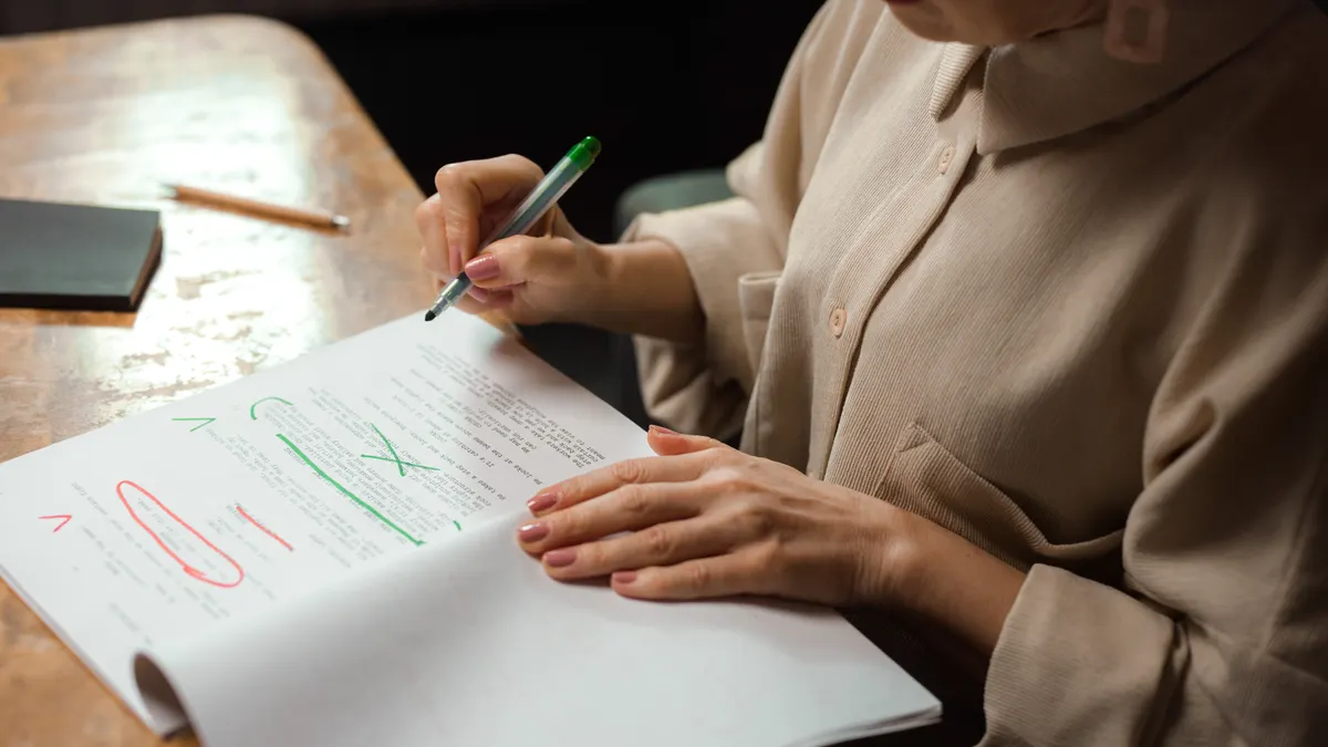 How to edit AI-generated content in batches without losing consistency person marking up a printed document with pen and notes