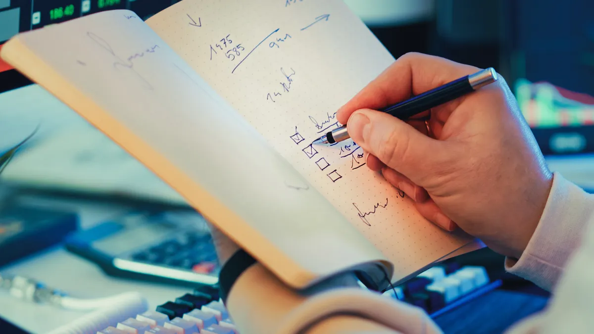 Hand checking boxes in an open notebook