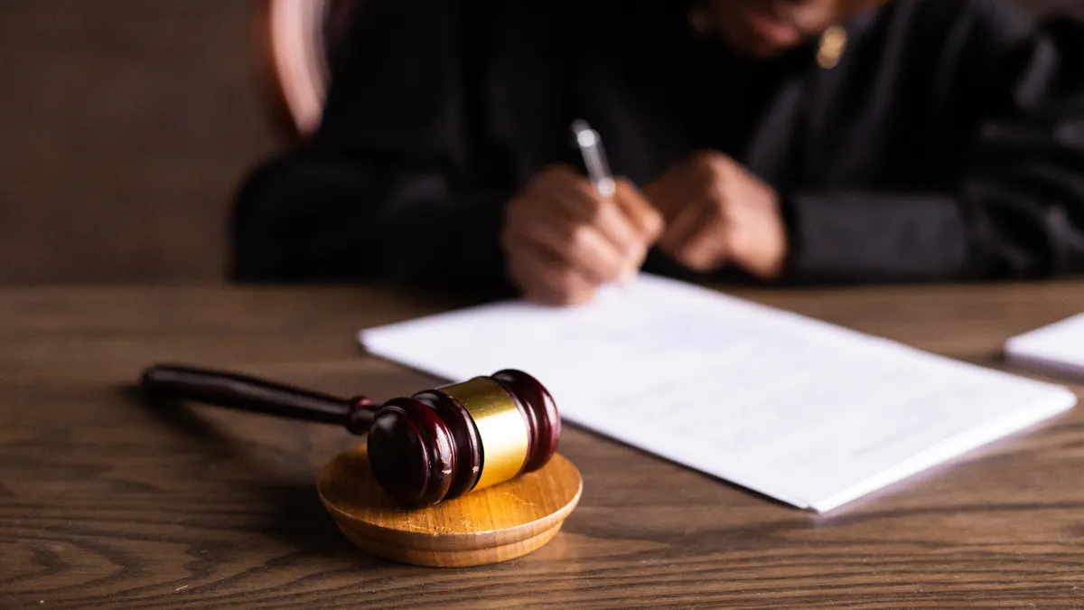gavel on table with person signing papers