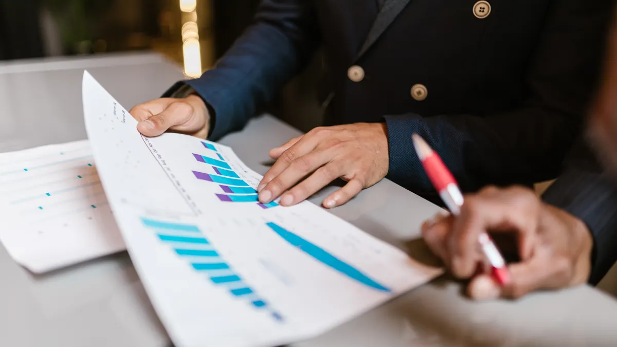 People reviewing printed performance charts at a table