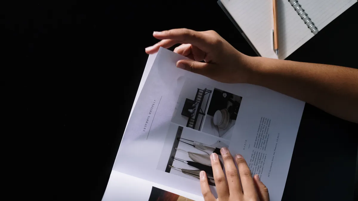 hands reviewing a printed layout and notes